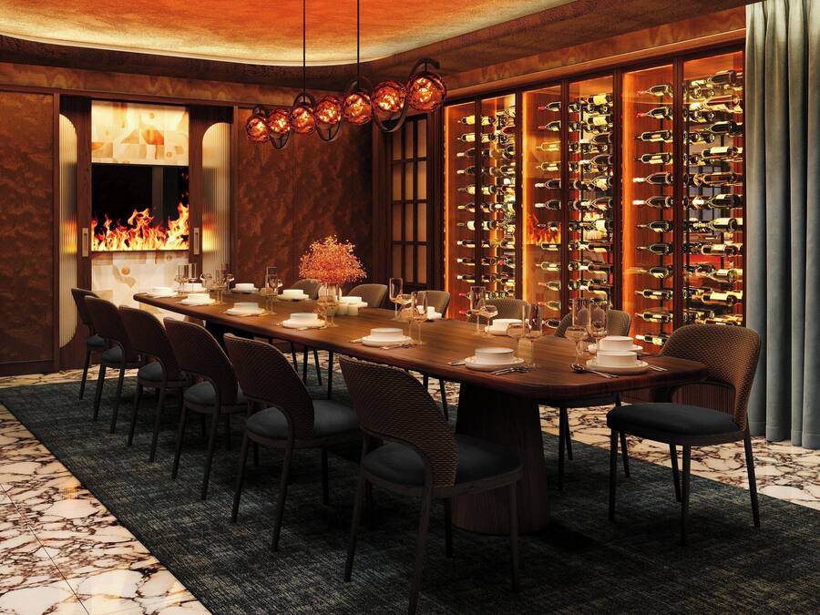 Un comedor elegante con una larga mesa, sillas, una estantería para vinos y una chimenea.