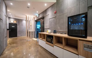 A modern hotel lobby with a reception desk, a refrigerator, and a water dispenser. - Cliff Bay Hotel (Busan)