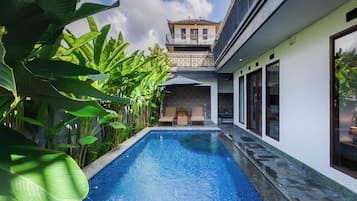 Alberca al aire libre y camastros