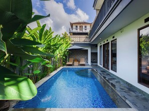 A swimming pool with a view of a building and lush greenery.