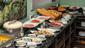 Un buffet proposant une variété de plats, notamment des salades, de la viande et du pain.