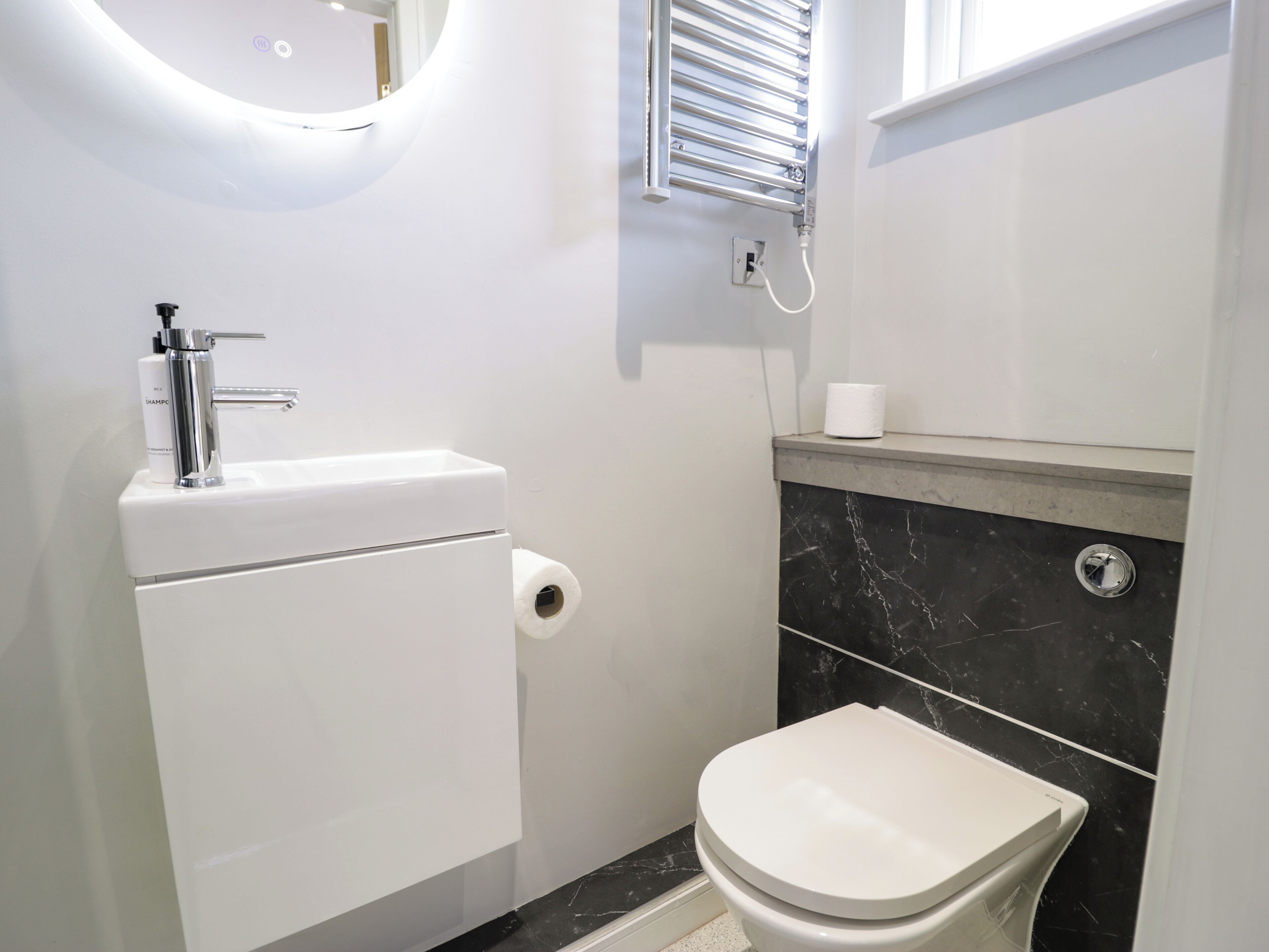 A compact bathroom with a toilet, a sink, and a mirror.