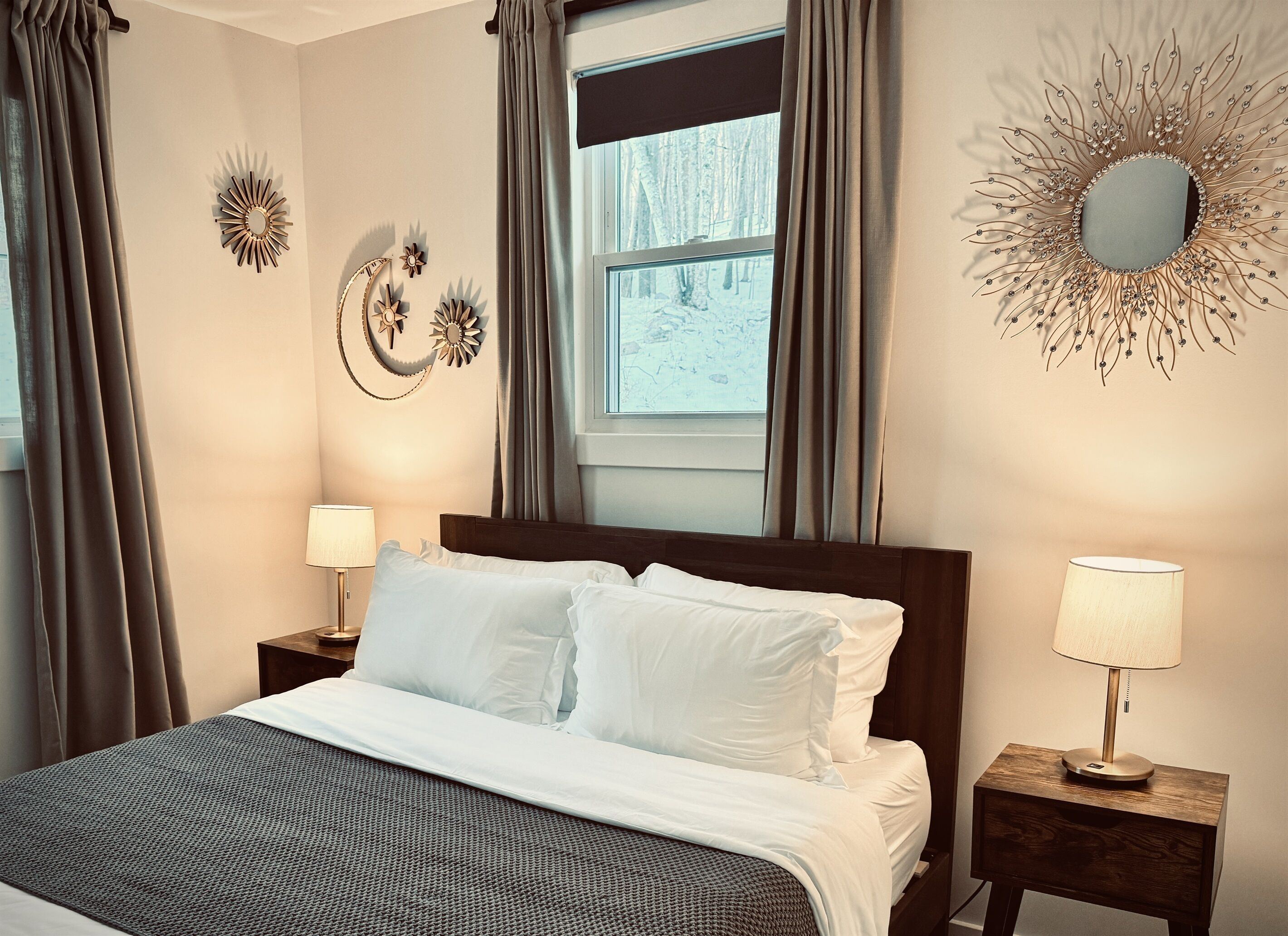 A neatly made bed with white linens, two bedside tables with lamps, and decorative wall art.