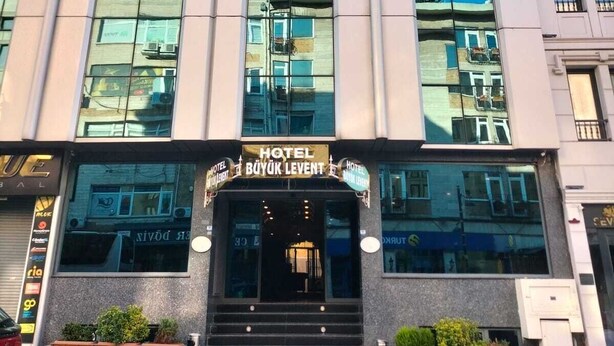 Un hotel moderno con una entrada destacada, amplias ventanas y un letrero que indica que es el Hotel Büyük Levent.