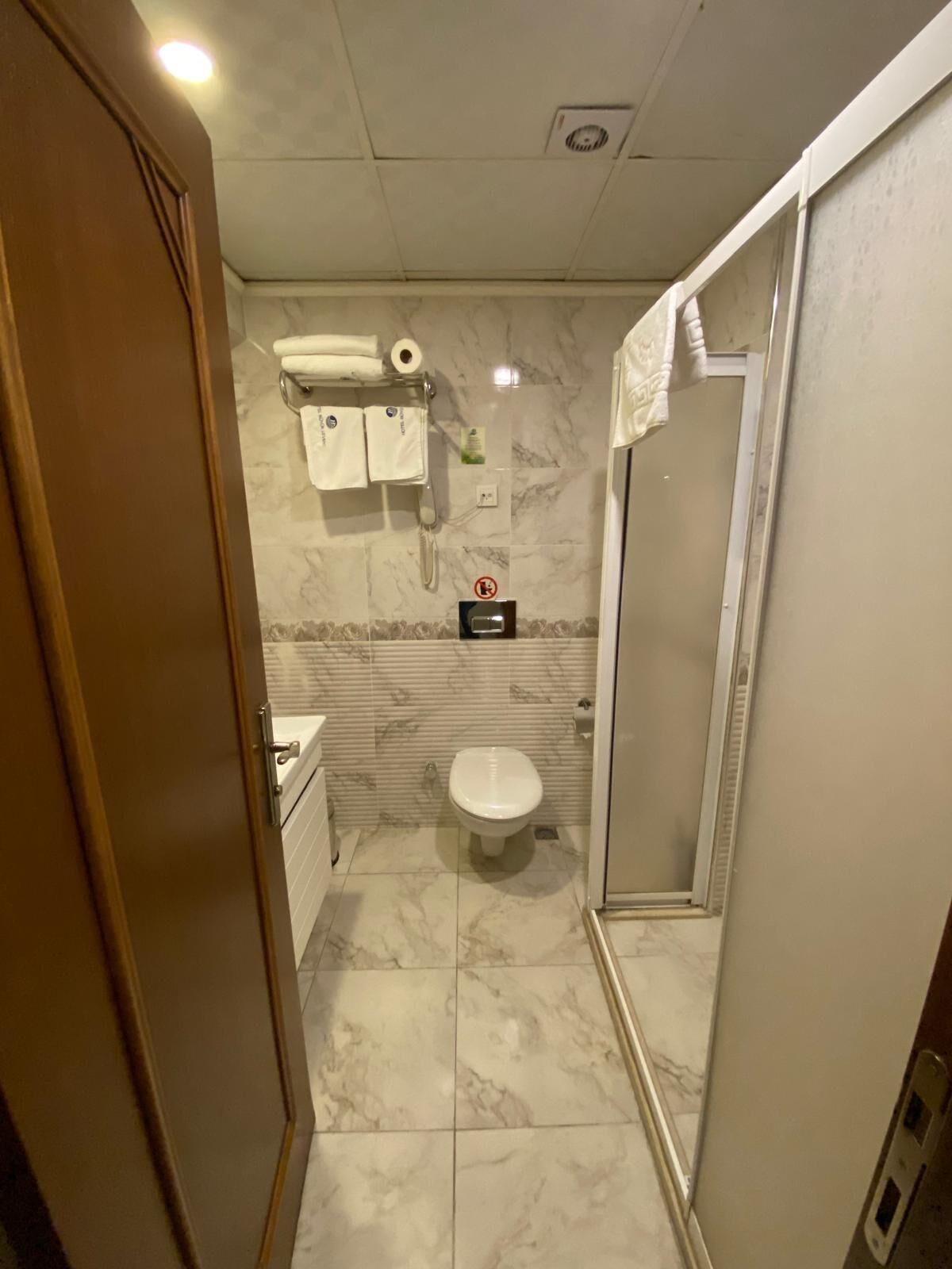 Une salle de bain comprenant des toilettes, un lavabo et un espace douche.