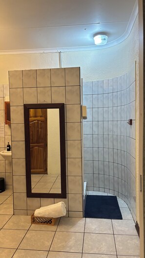 Chuveiro, toalhas de banho, sabonete, papel higiênico