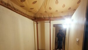 Un couloir étroit avec une armoire en bois et un grand miroir mural.