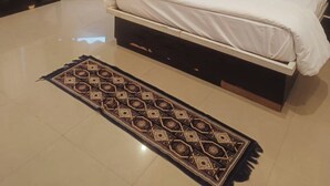 Une chambre à coucher avec un lit, un bureau et un tapis à motifs.