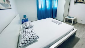A modern bedroom with a bed, a nightstand, a lamp, a small table, and a mirror. - Apartment Paulina - 3-bedroom apartment in charming Trogir with WiFi, AC (Trogir)