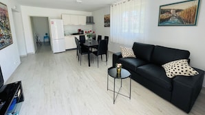 A modern apartment with a dining area, a black leather sofa, and a small side table. - Apartment Paulina - 3-bedroom apartment in charming Trogir with WiFi, AC (Trogir)