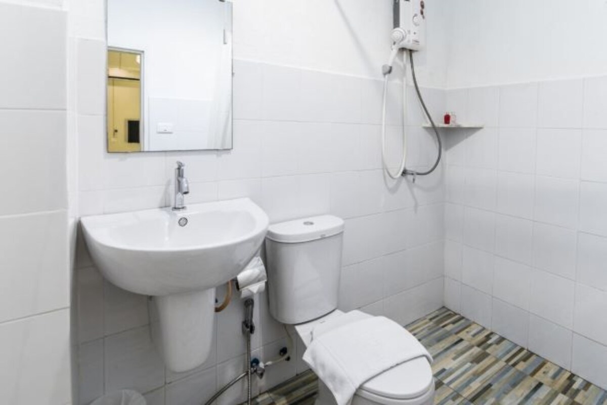 A bathroom with a white sink, toilet, and shower.