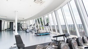 A modern gym with various exercise equipment, large windows, and a clean, spacious layout. - I City Luxury Condo Shah Alam Smarthome (Shah Alam)