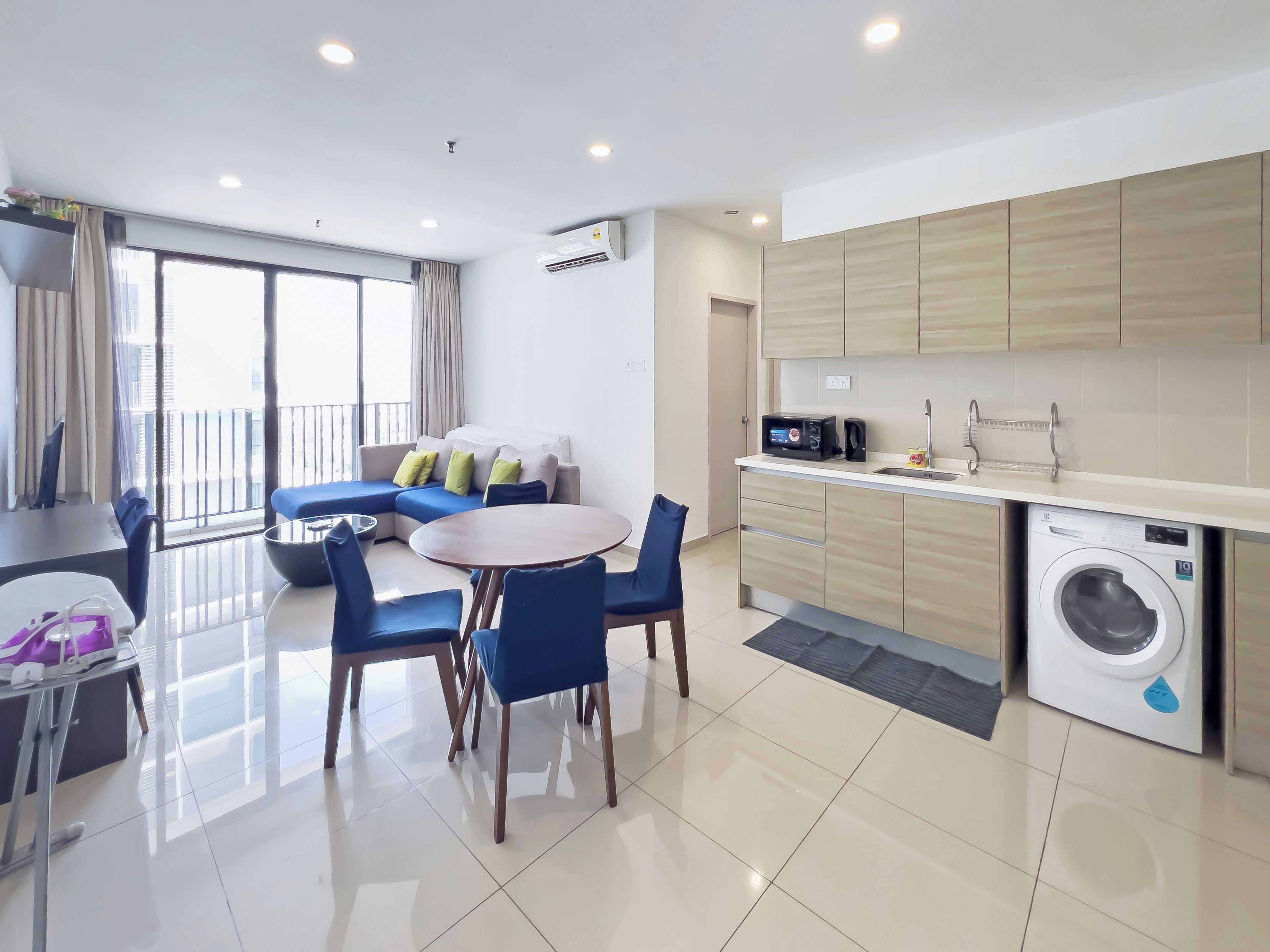 Un appartement moderne comprenant un coin repas, une cuisine équipée d’un lave-linge et un balcon avec vue.