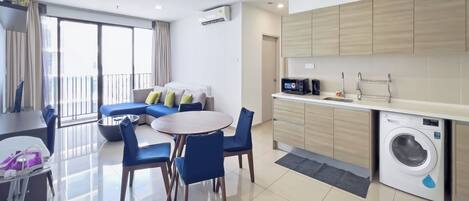 Un appartement moderne comprenant un coin repas, une cuisine équipée d’un lave-linge et un balcon avec vue.