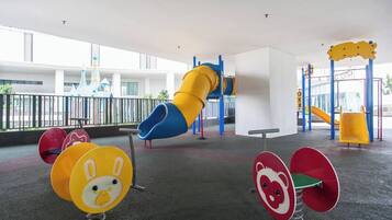 A playground with a slide, swings, and colorful play equipment.