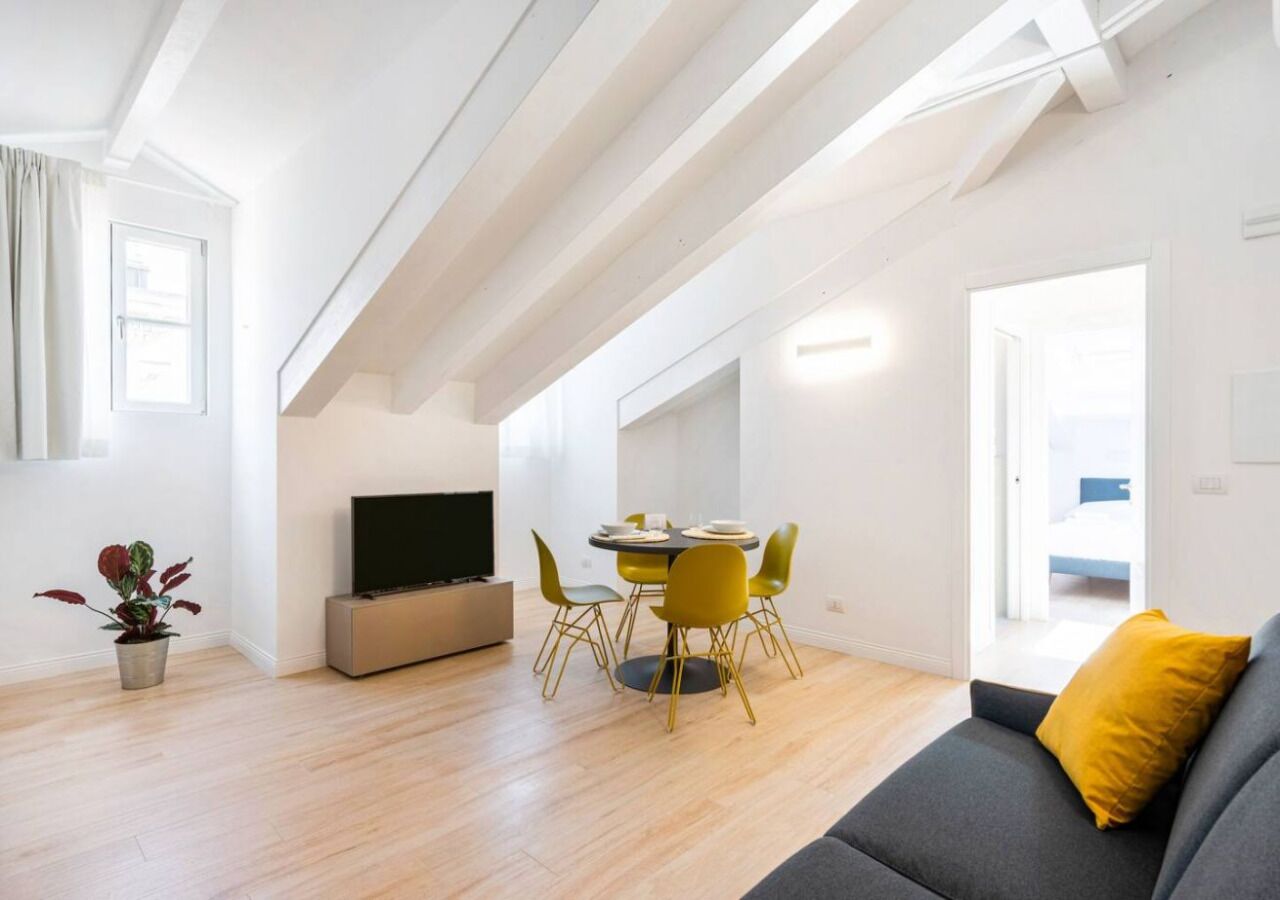 Un apartamento moderno con comedor, sofá y televisor.