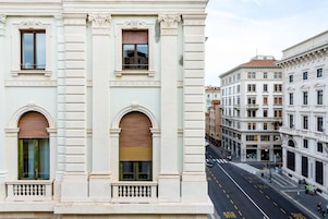 Una vista di strada di un edificio con architettura classica, caratterizzato da finestre ad arco e un ingresso centrale.