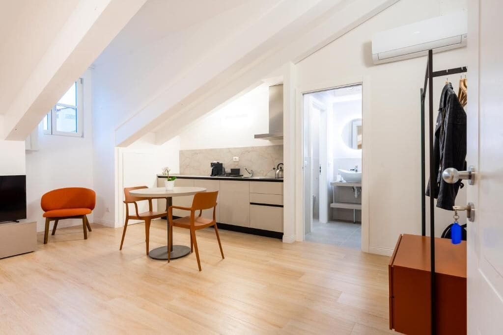 Una cocina moderna con comedor, televisor y perchero.