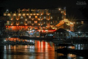 A multi-story building with a traditional architectural style, featuring a prominent roof with decorative elements. - Capital O 91170 Kurau Bay Hotel (Kuala Kurau)