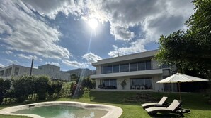 A modern house with a swimming pool, a sun umbrella, and a well-maintained lawn. - A special retreat in Ishigaki Island｜Private villa exclusively for one group per day (ishigaki city)