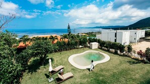 A backyard with a swimming pool, lounge chairs, and a view of the ocean. - A special retreat in Ishigaki Island｜Private villa exclusively for one group per day (ishigaki city)