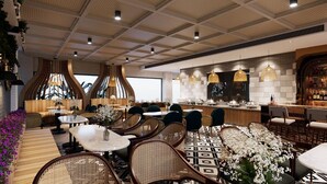 Ein modernes Restaurant mit Korbmöbeln, einer Bar und Blick durch große Fenster.