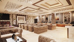 Eine luxuriöse Lobby mit bequemen Sitzgelegenheiten, Kronleuchtern und einer Rezeption.