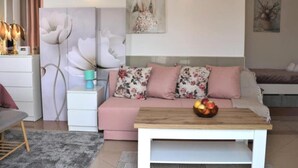 Un salon moderne avec un canapé, une table basse et un tableau accroché au mur.