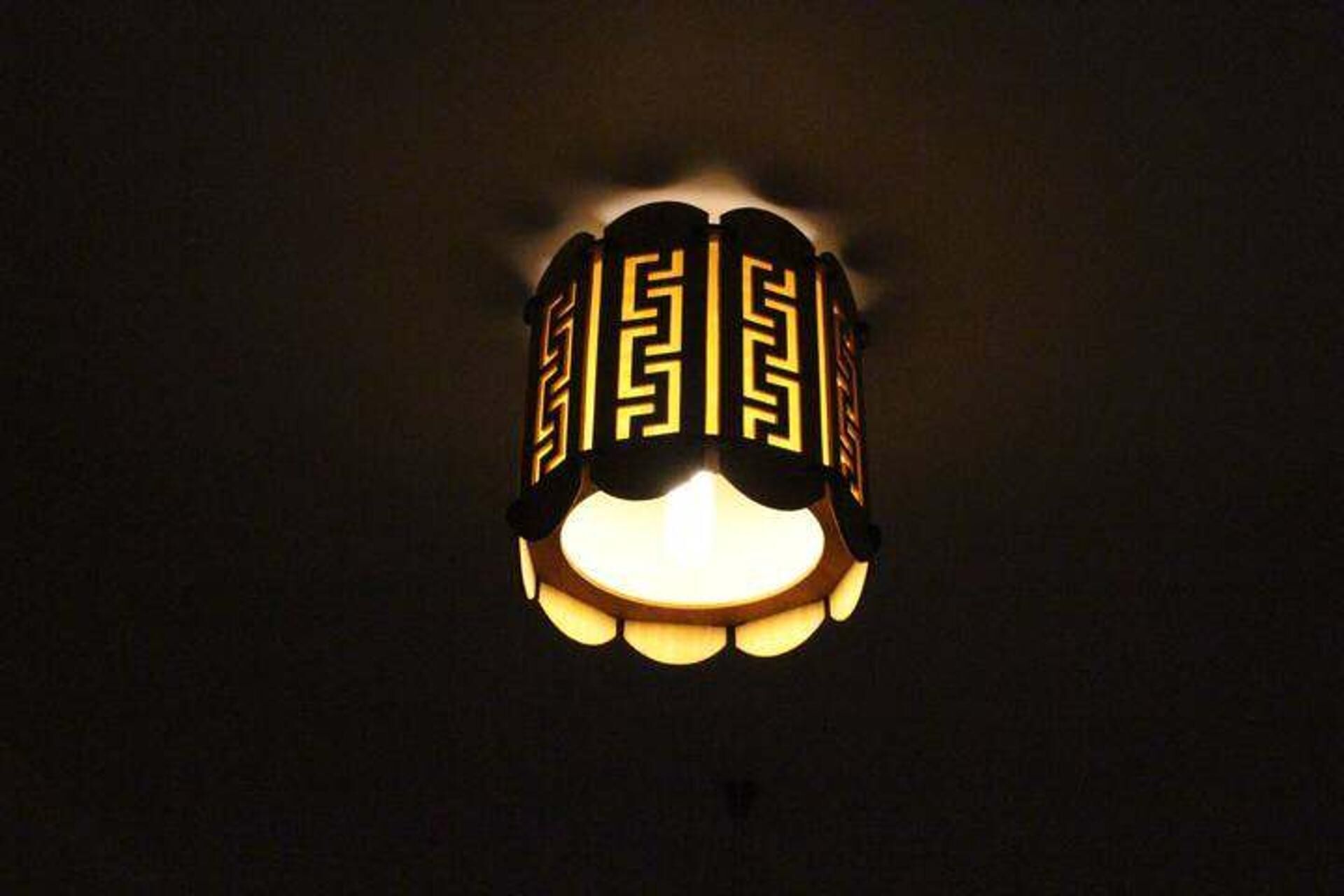 A wall-mounted light fixture with a geometric pattern.