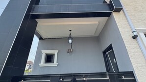 Ein modernes, mehrstöckiges Gebäude mit flachem Dach, großen Fenstern und einem Balkon.