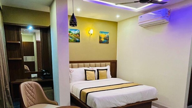 Ein modernes Hotelzimmer mit Bett, Schreibtisch, Stuhl und Deckenventilator.