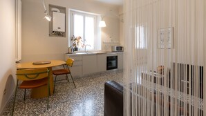 A compact kitchen with a dining area, a microwave, and a sink. - Cosy two-room apartment Porta Romana - Mirable PM (Milan)