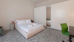 A hotel room with a bed, a nightstand, a green chair, and a wardrobe. - Cosy two-room apartment Porta Romana - Mirable PM (Milan)
