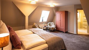 A bedroom with a bed, a chair, a cabinet, and a skylight. - Large apartment with 210 sqm for up to 10 people in country house villa (Alt Necheln)