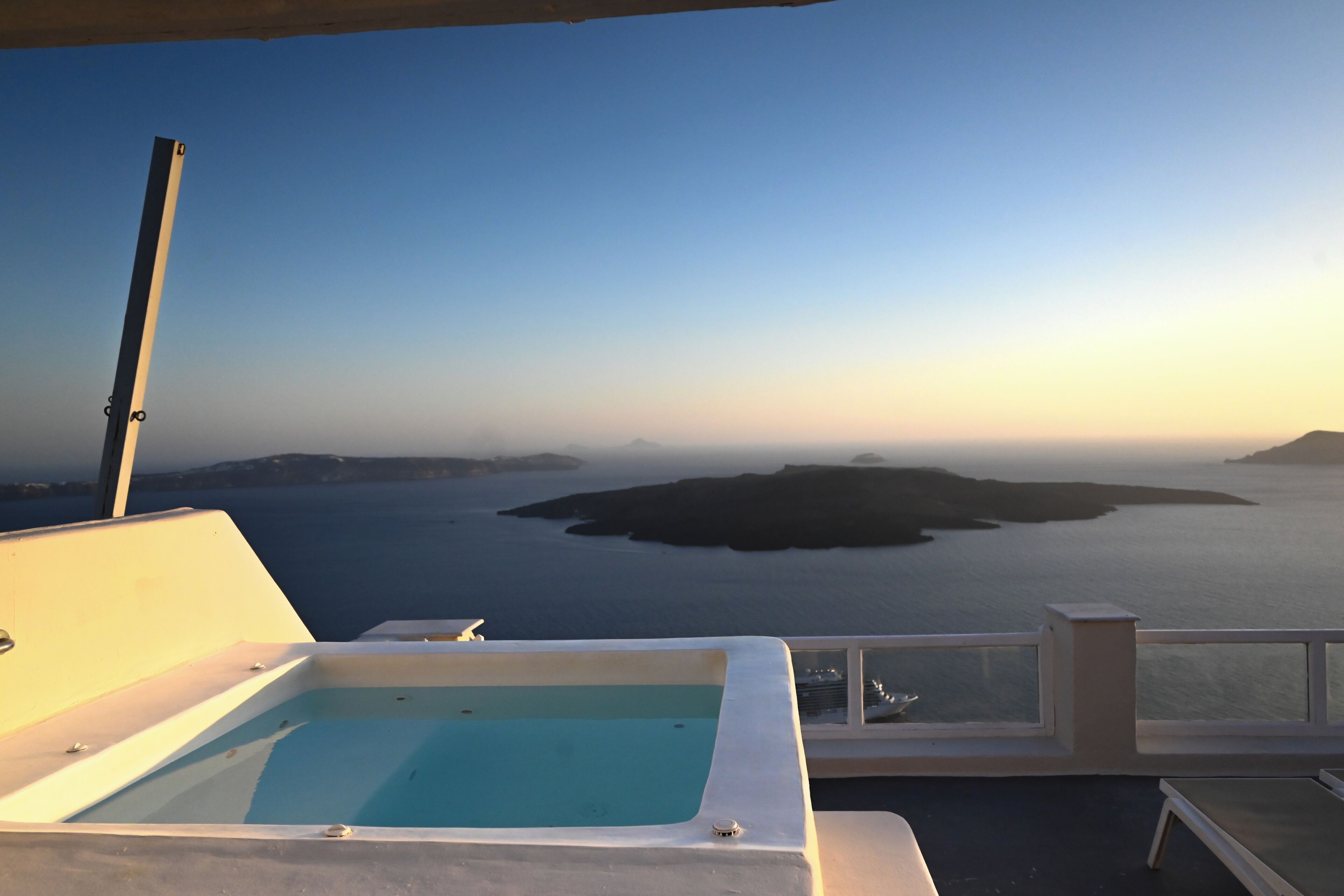 A pool with a view of the sea and islands.