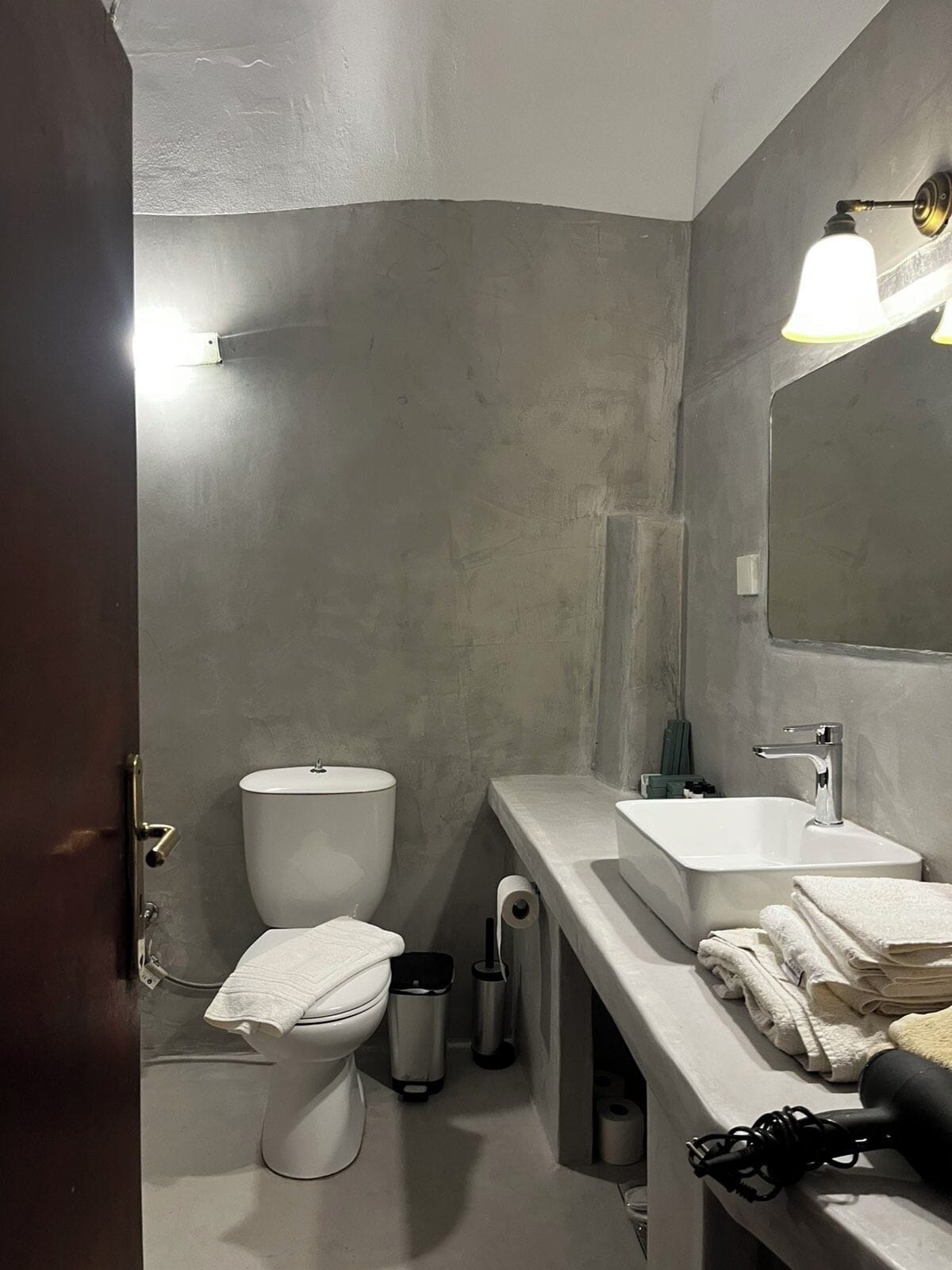A modern bathroom with a toilet, sink, and mirror.