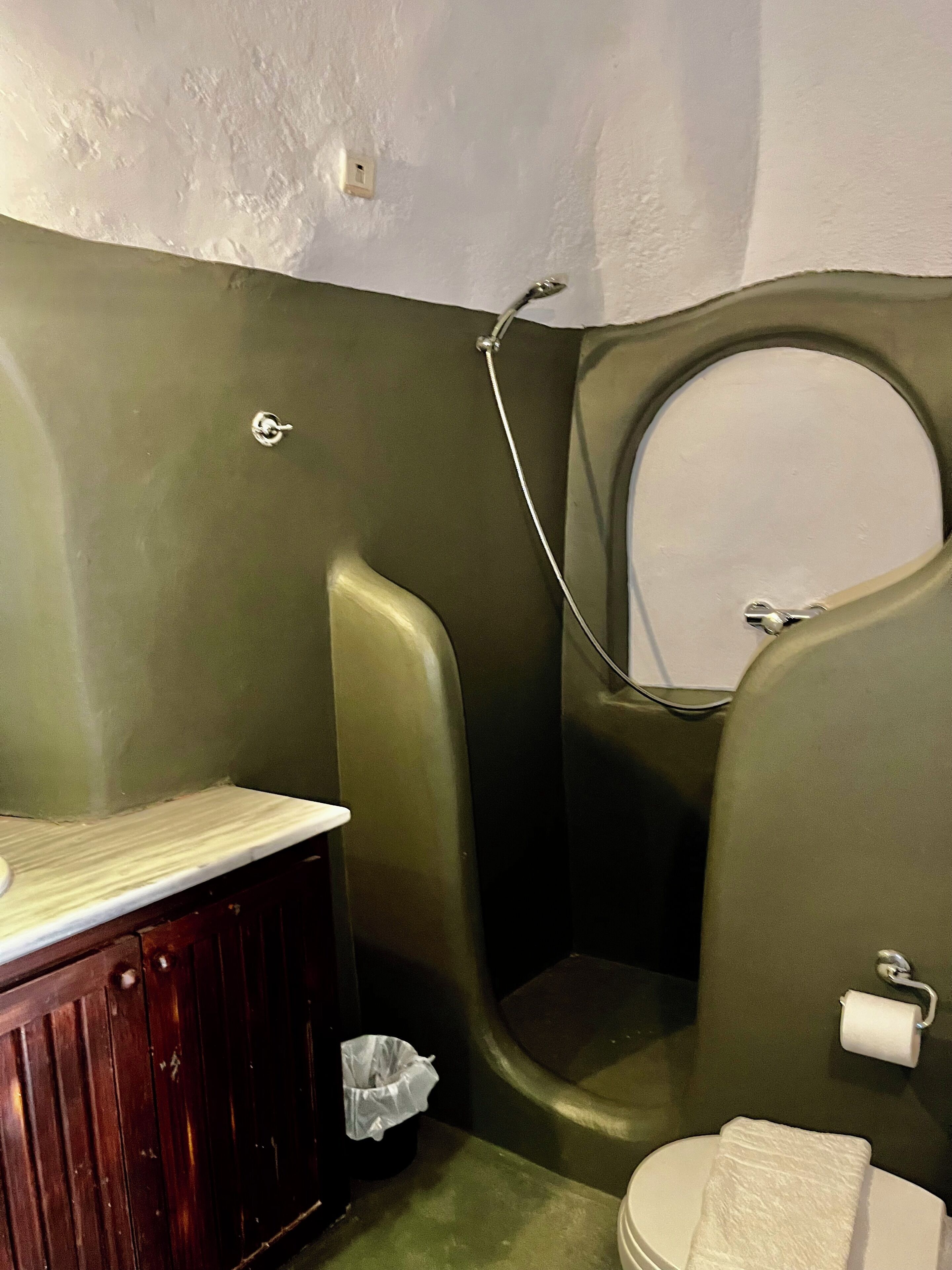 Un baño con inodoro, lavabo y cubo de basura.
