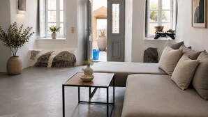 Uma sala de estar ampla com um sofá, uma mesa de centro e um vaso de plantas.