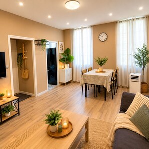 A modern living room with a dining area, a sofa, a coffee table, and a TV.