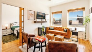 A modern living room with a sofa, chairs, a coffee table, and a fireplace. - Paloma on Main — Downtown View, Sheridan WY (Sheridan)