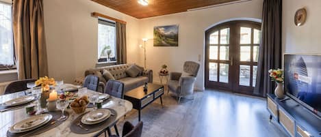 Una sala de estar con comedor, un sofá, un televisor y una chimenea.