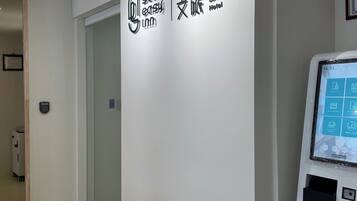 A hotel check-in kiosk with a digital screen displaying various options.
