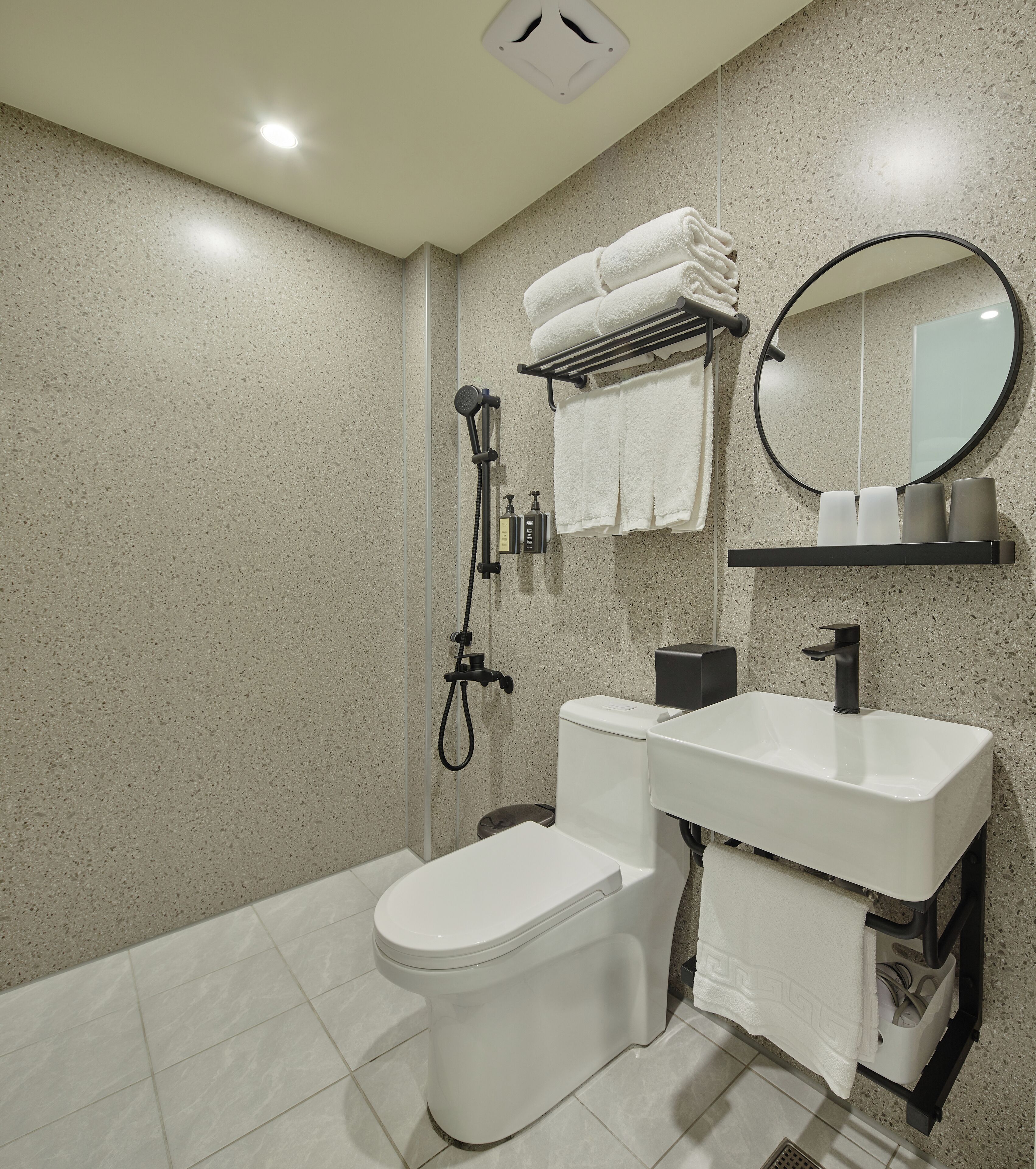A modern bathroom with a toilet, sink, and shower.