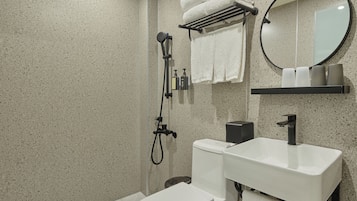 A modern bathroom with a toilet, sink, and shower.