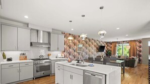 Une cuisine moderne avec des armoires blanches, une cuisinière en acier inoxydable et un lave-vaisselle.