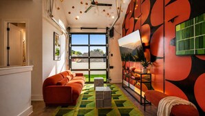 Un salon moderne avec un canapé, une table basse et un téléviseur.