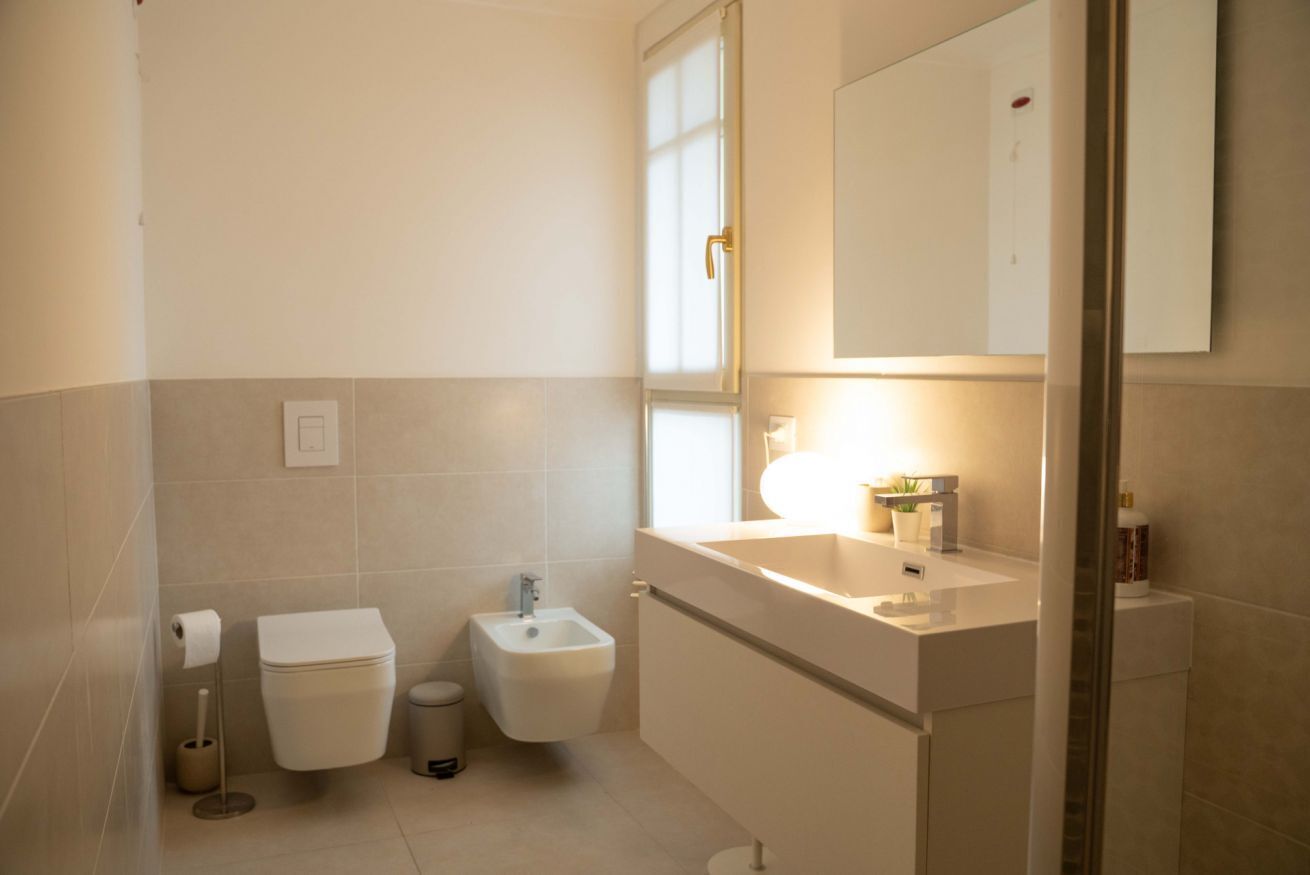 Ein modernes Badezimmer mit Toilette, Bidet und Waschbecken.