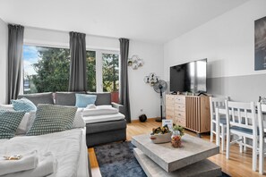 Una sala de estar moderna con un sofá, una mesa de centro y un televisor.