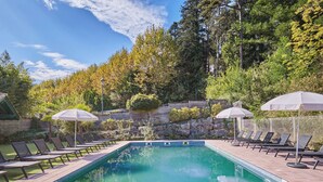 A rectangular swimming pool with a tiled edge, surrounded by lounge chairs and umbrellas. - Villas Odalys Collection Domaine de Lana by Interhome (Saint-Jean-de-Luz)