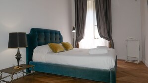 Una camera da letto con un letto grande, un comodino con una lampada e una finestra con tende.